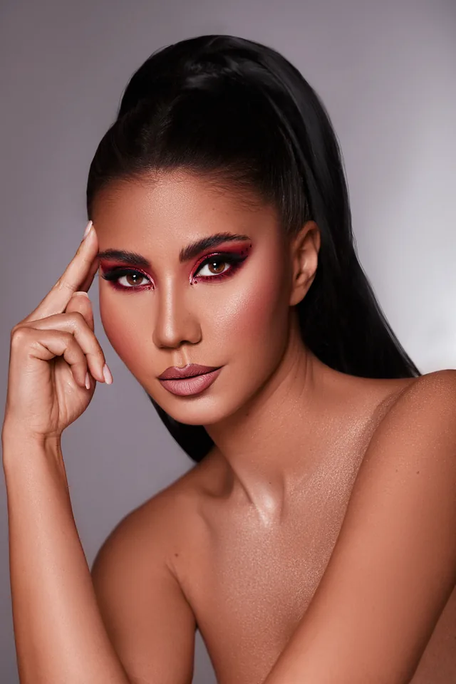 Glamour-Make-up mit rotem Lidschatten und hohem Sleek-Pferdeschwanz