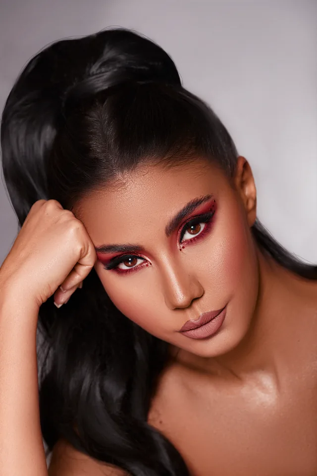 Editorial-Make-up mit roten Smokey Eyes und glattem Pferdeschwanz